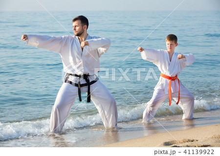 Teacher and boy doing karate poses 41139922