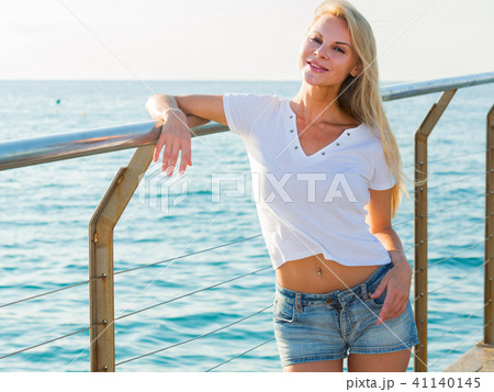 Cheerful female is posing playfully on pirce in her free time Cheerful female is posing playfully on pirce in her free time 41140145