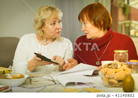 Worried mature female friends with papers Worried mature female friends with papers 41140802