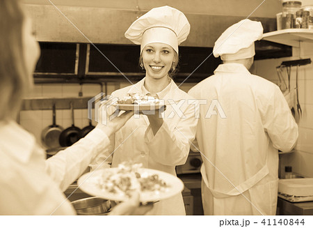 Waitress taking dish from kitchen Waitress taking dish from kitchen 41140844