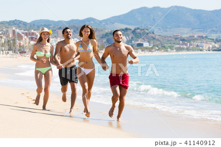 Adults running at sandy beach 41140912