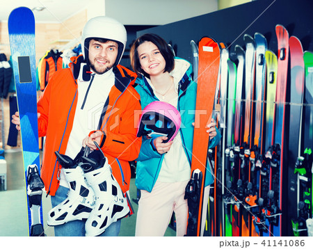 Man and woman standing with purchased ski equipment in shop Man and woman standing with purchased ski equipment in shop 41141086