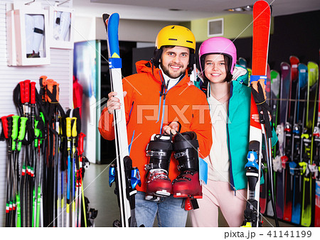 Man and woman standing with purchased ski equipment in shop Man and woman standing with purchased ski equipment in shop 41141199