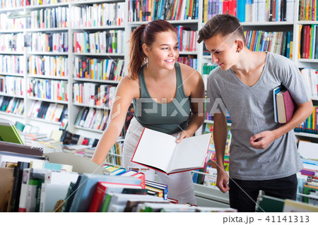 girl and boy teenagers in book store. girl and boy teenagers in book store. 41141313