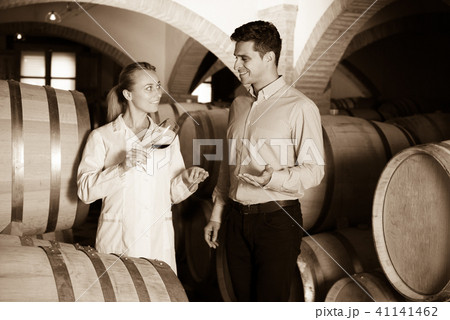 Sommelier advising male customer in winery cellar Sommelier advising male customer in winery cellar 41141462