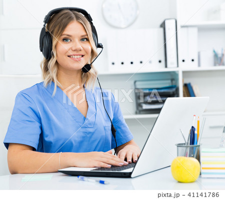 Attentive specialist of medical call center in headphones in office 41141786