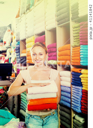 Young woman buying soft towels in textile store 41141842