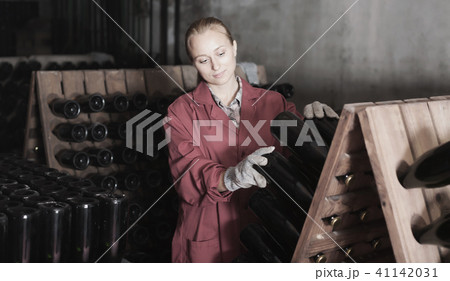 Cheerful woman winery employee working in cellar Cheerful woman winery employee working in cellar 41142031