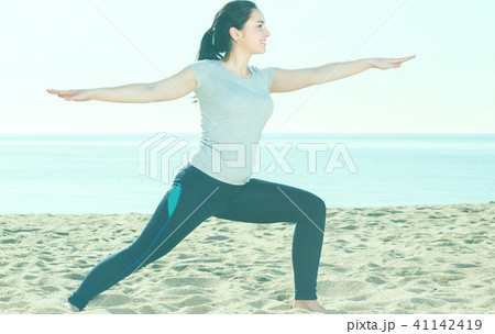 Positive young girl training yoga poses Positive young girl training yoga poses 41142419