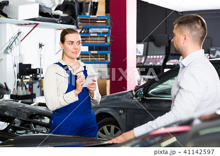 Woman mechanic with male client Woman mechanic with male client 41142597