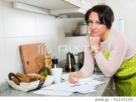 Sad housewife reading bills and crying Sad housewife reading bills and crying 41143150