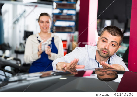 Male customer examining car body after repainting Male customer examining car body after repainting 41143200