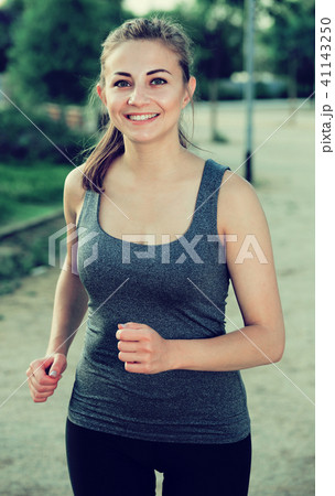 positive female in sportwear running in the sunny park positive female in sportwear running in the sunny park 41143250