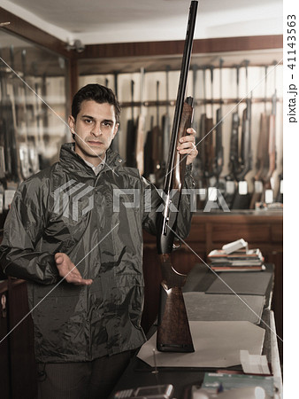 Portrait of glad confident man showing rifle Portrait of glad confident man showing rifle 41143563