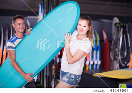 couple is posing in surfboard store on the beach. couple is posing in surfboard store on the beach. 41143645