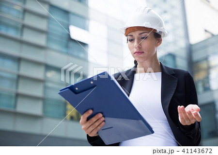 Woman architector in suit and hat is dissatisfieded of documents with project 41143672