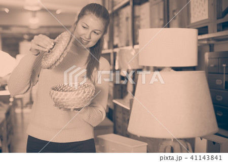 Positive woman buyer holding wicker basket 41143841