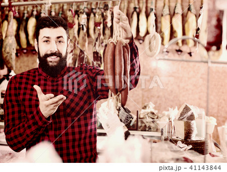 Young male customer examining sausages in butcher’s shop 41143844