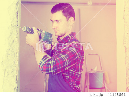 Professional worker standing with drill in hands Professional worker standing with drill in hands 41143861