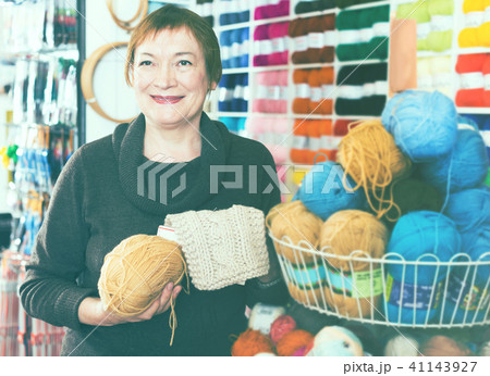 Woman picking yarn in shop Woman picking yarn in shop 41143927