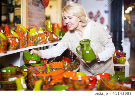 Woman customer holding ceramic cookware at workshop 41143983