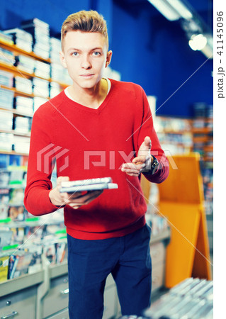 Guy holding CD in shop 41145096