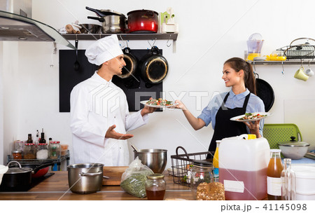 Man cook giving to waitress ready to serve salad 41145098