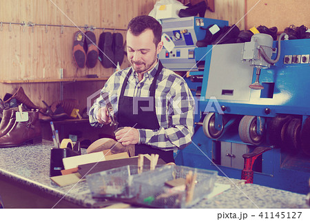 Male worker repairing shoe Male worker repairing shoe 41145127