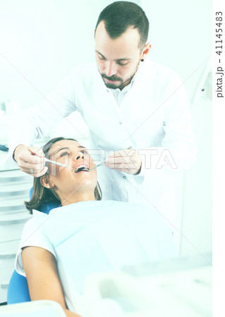 Dentist is treating woman patient which is sitting chair in clinic Dentist is treating woman patient which is sitting chair in clinic 41145483
