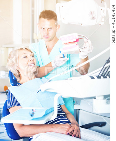 Dentist explaining to patient correct tooth brushing 41145484