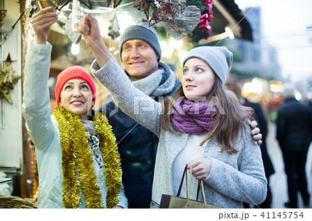 happy family couple with teen girl choosing Christmas decoration happy family couple with teen girl choosing Christmas decoration 41145754