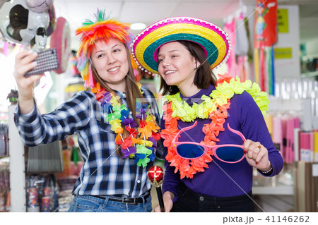 Girls taking selfie in store of festival accessories Girls taking selfie in store of festival accessories 41146262