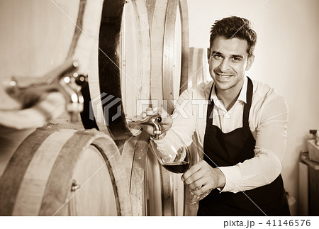Man pouring red wine into glass in alcohol section Man pouring red wine into glass in alcohol section 41146576