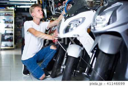 concentrated man motorcyclist choosing the bike in the shop 41146699