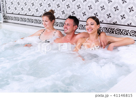 Company of three people relaxing enjoying jacuzzi 41146815