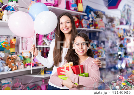 smiling woman and daughter with gifts and balloons in the shop smiling woman and daughter with gifts and balloons in the shop 41146939