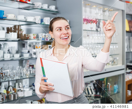 Young woman buyer holding catalogue, looking new tableware Young woman buyer holding catalogue, looking new tableware 41146981