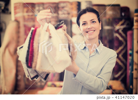 Young woman shopping carpet and showing samples Young woman shopping carpet and showing samples 41147020