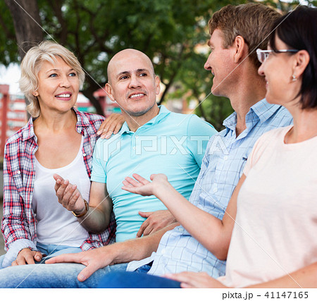 Portrait of mature cheerful males and females talking outdoors Portrait of mature cheerful males and females talking outdoors 41147165
