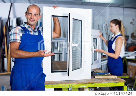 Confident man in workwear with finished window from pvc profile at workplace 41147424