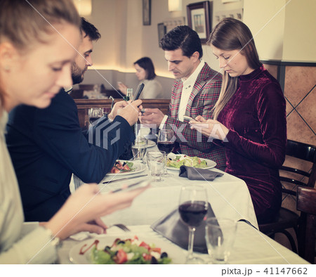 Modern young people with phone at restaurant 41147662