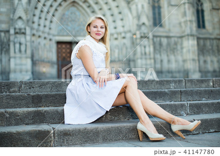 smiling woman sitting in the city center in shawl 41147780