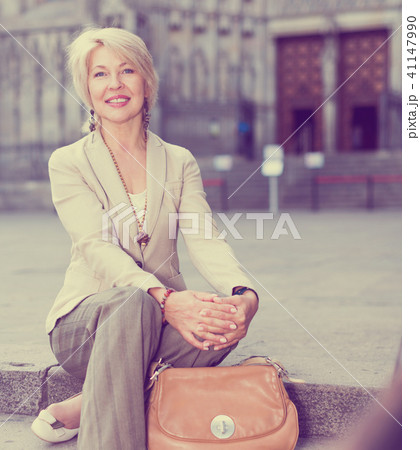 Adult woman 50-60 years old is sitting in time walking 41147990