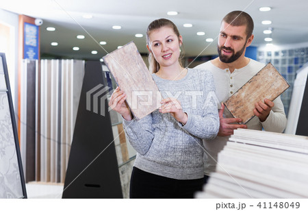 Positive couple holding sample of kitchen ceramic tile Positive couple holding sample of kitchen ceramic tile 41148049
