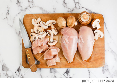raw chicken fillets on wooden cutting board raw chicken fillets on wooden cutting board 41150678