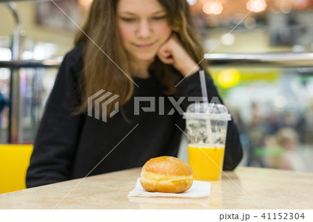 Teenage girl in cafe eating cake Teenage girl in cafe eating cake 41152304