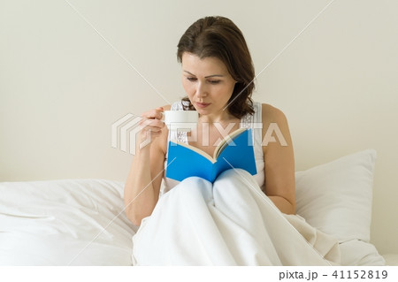 Mature woman in bed reading book 41152819