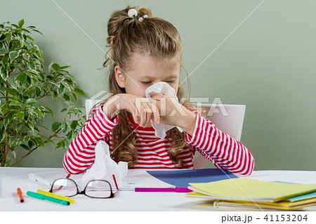 girl child in glasses sneezing in a tissue blowing 41153204