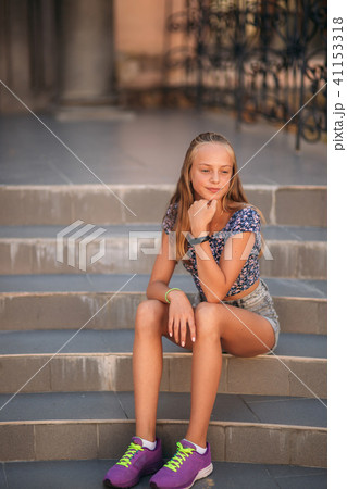 teenage female dressed in jeans sits on stairs teenage female dressed in jeans sits on stairs 41153318