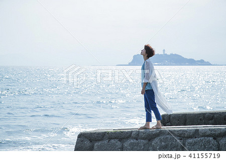 海 散歩 女性 砂浜 海岸 旅行 観光 海辺 リラックスの写真素材